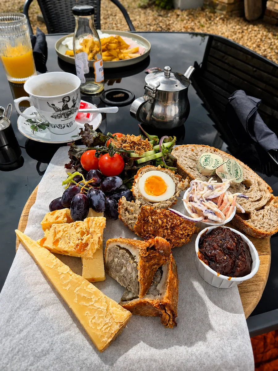 An outdoor tea and lunch spread with salad, sandwiches and cake